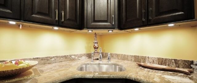 Warm under cabinet lighting illuminating a granite countertop in a Prescott kitchen
