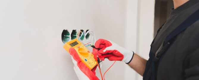 Prescott electrician using a multimeter to test wires before rewiring a house