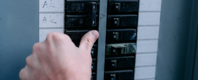 Homeowner checking a overheating electrical panel or circuit breaker