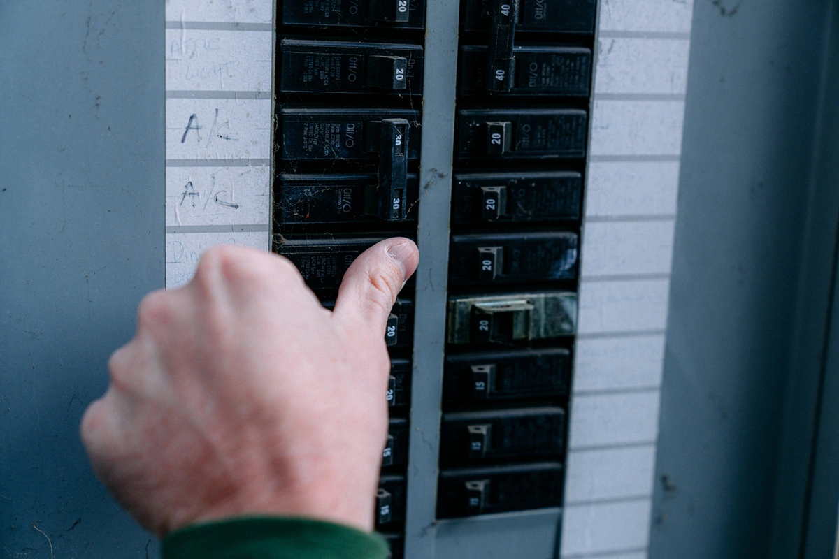 Homeowner checking a overheating electrical panel or circuit breaker