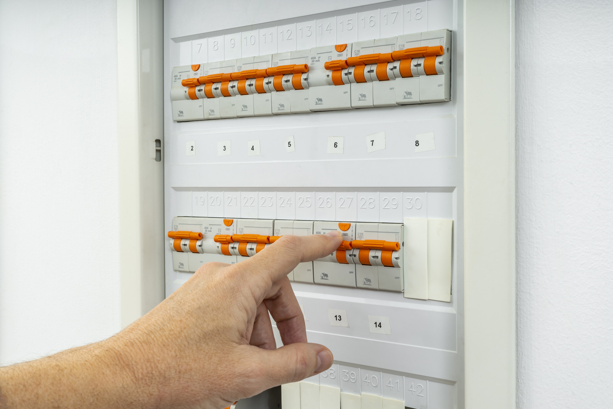 male hand resetting tripped circuit breaker
