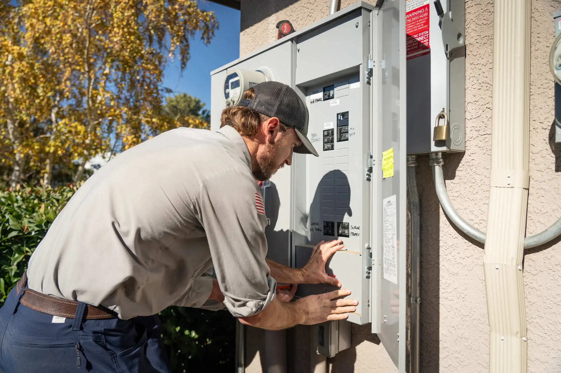 Licensed Electrician of Assurance Electrical Services inspecting an outdoor electrical panel