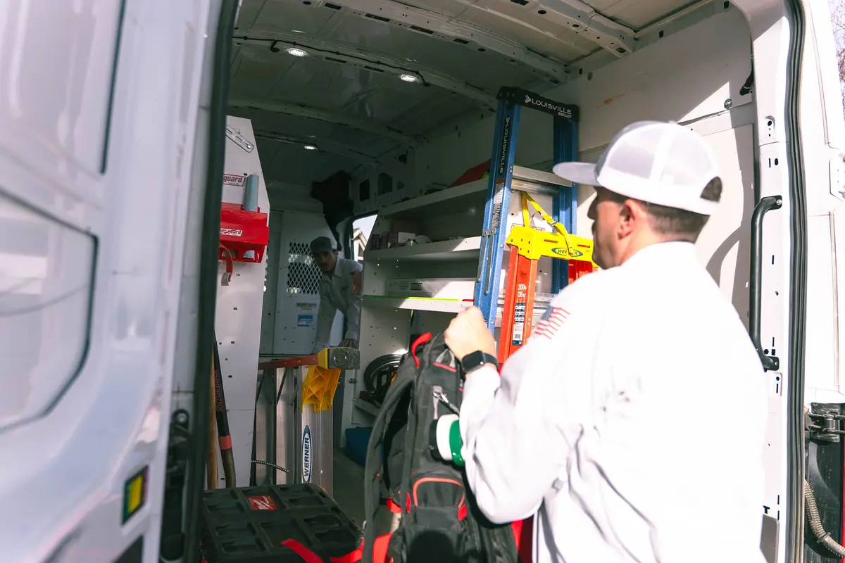 How to prepare for an electrical service upgrade: an electrician loads tools into a service van for work.
