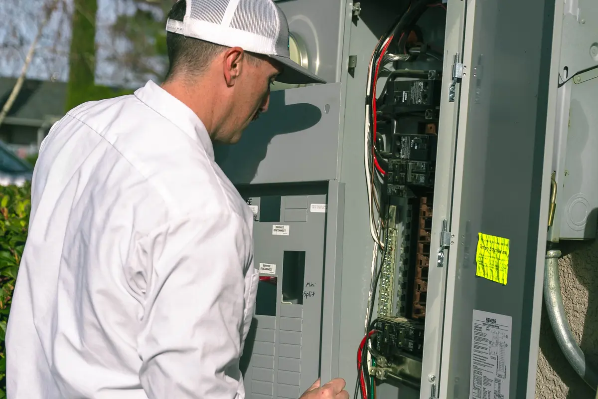 What is an electrical panel board testing breakers Gloved technician tests breakers in the control box; what is an electrical panel board?