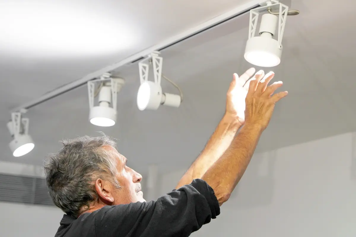 Electrician upgrading to LED lighting throughout the house with a ceiling spotlight